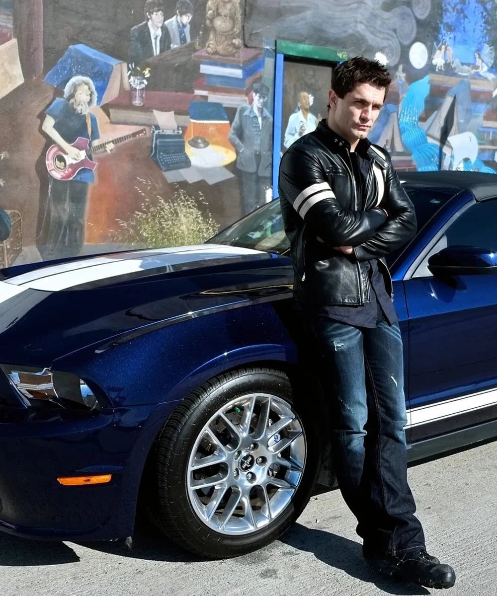 Actor Sam Witwer wearing Soul Revolver's black Driver San Francisco leather jacket beside a blue muscle car