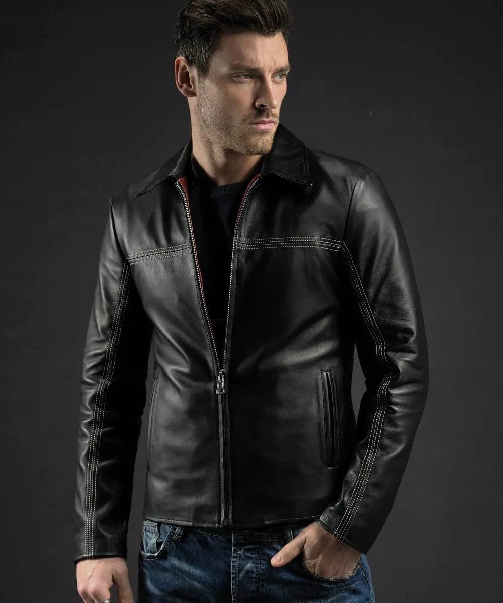 Male model wearing a black leather Layer Cake movie replica jacket with slim fit styling, vintage collar, contrast stitching, and minimalist zip front detailing paired with dark denim jeans