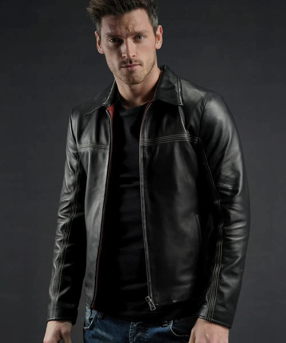 Male model wearing a black leather Layer Cake jacket with slim fit styling, vintage collar, contrast stitching, and minimalist zip front detailing over a black shirt