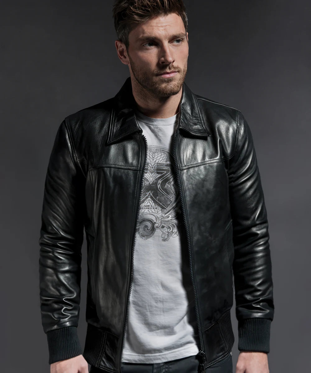Model wearing vintage black leather bomber jacket with slim fit styling and ribbed knit trim