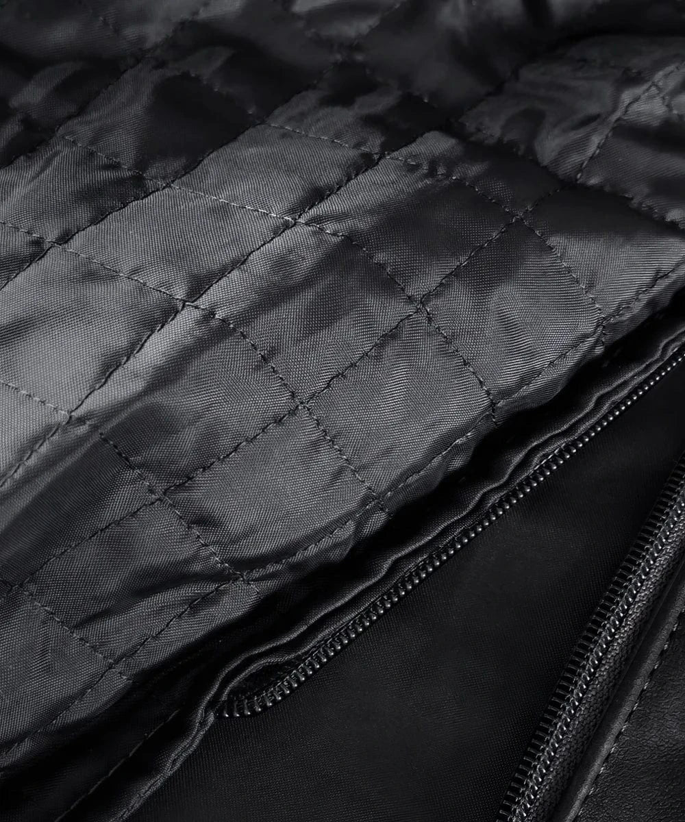 Close-up view of quilted black lining and inner zipper detail inside slim fit black leather jacket